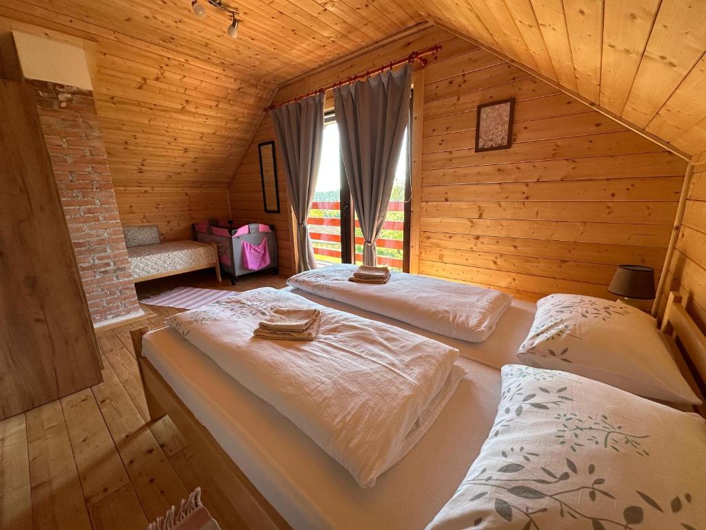 a room with two beds in a wooden cabin at Resort Dudukovic 1 in Slunj