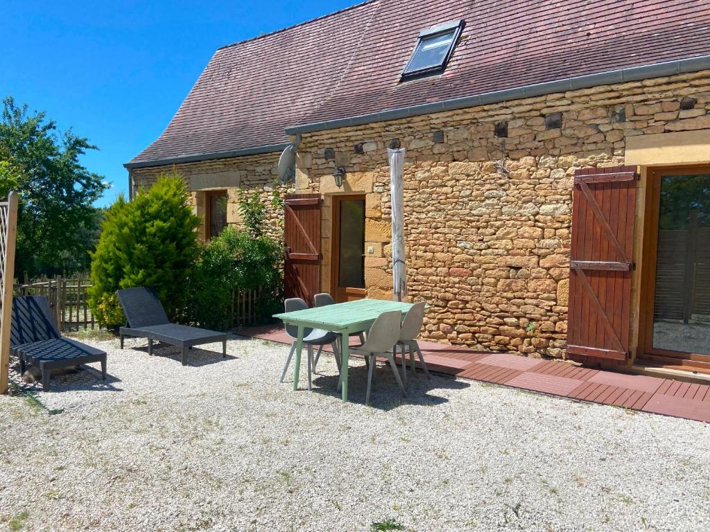 une table et des chaises devant un bâtiment en pierre dans l'établissement Gite en pierres à la campagne, à Tamniès