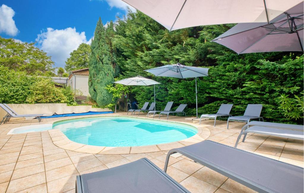 einen Pool mit Stühlen und Sonnenschirmen im Hof in der Unterkunft Nice Home In Sarlat-La-Canéda in Sarlat-la-Canéda