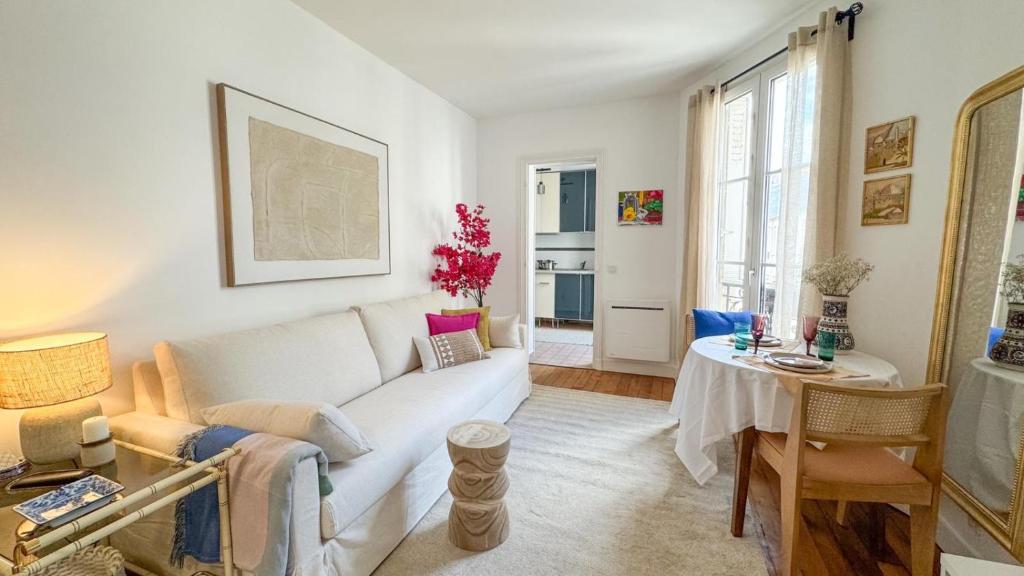 un salon avec un canapé blanc et une table dans l'établissement Escapade parisienne stylée, à Paris