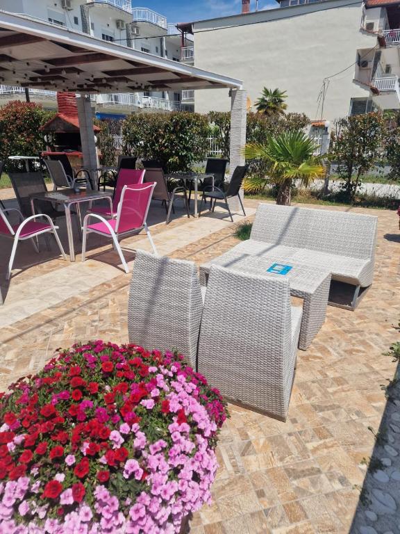 a patio with chairs and a table and flowers at Pension Delfini in Asprovalta