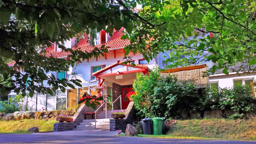 マートラゼンティムレにあるMátraszentimre Panzióの赤い屋根と階段を前に建つ家