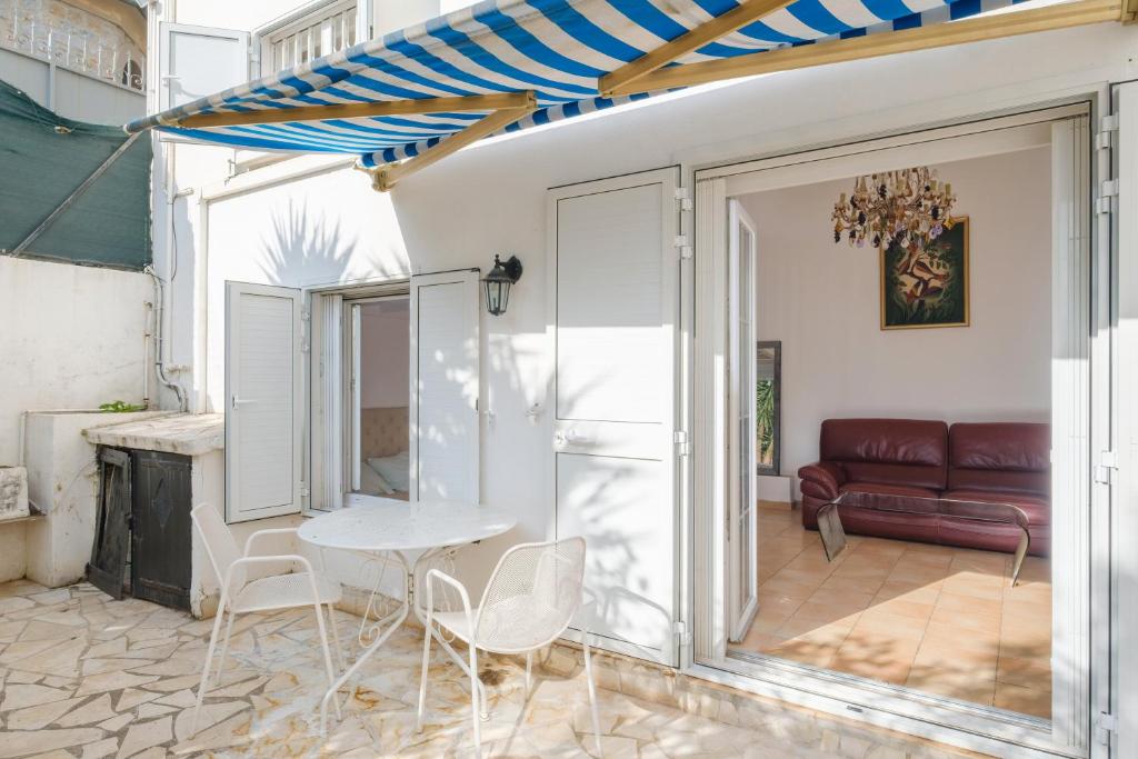 un salon avec une table, des chaises et un canapé dans l'établissement Maison Centre Cannes Avec Terrasse, à Cannes