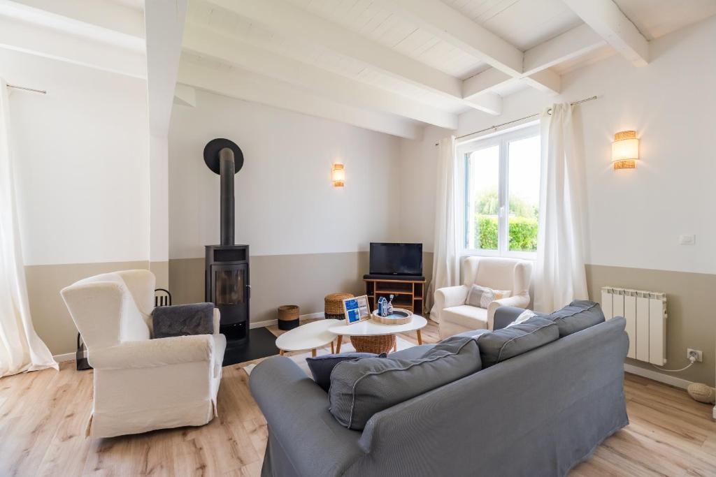 un salon avec un canapé et une table dans l'établissement Un Air de Famille - proche de la plage, à Pleubian