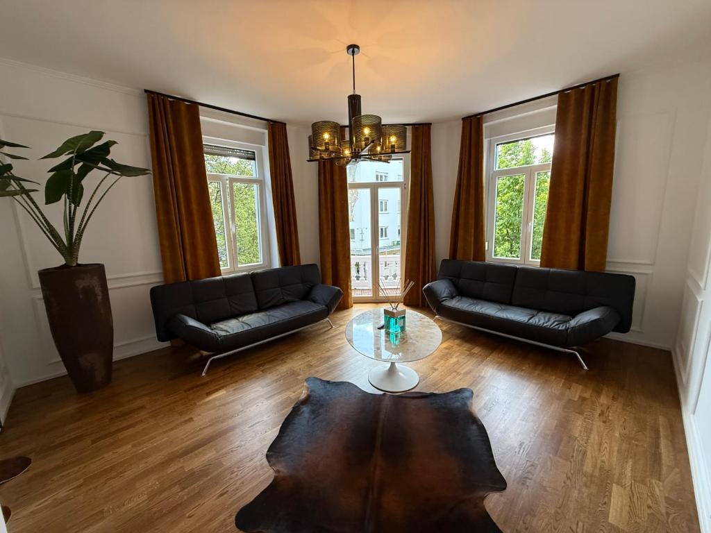 a living room with two couches and a table at Historical Luxury Homes - Familiensuite mit Terrasse in Freiburg im Breisgau