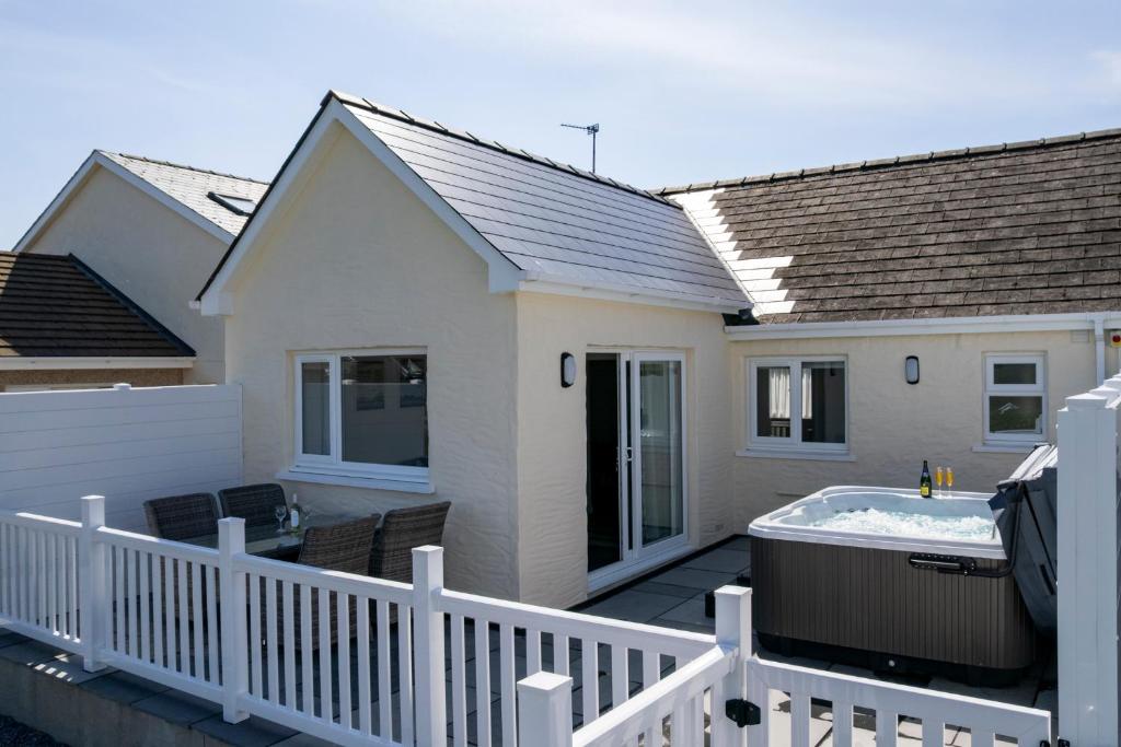 a house with a hot tub on a deck at Bramble Cottage - Dog Friendly Cottage Hot Tub in Begelly