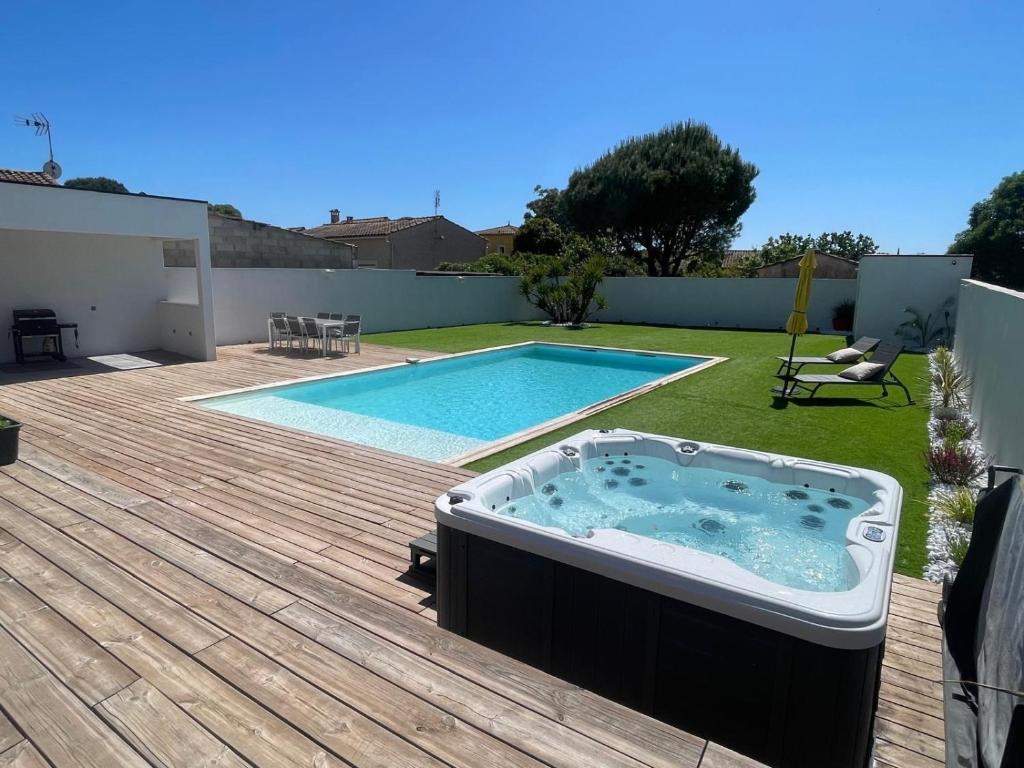 un bain à remous sur une terrasse à côté d'une piscine dans l'établissement Villa Noam Haut Standing 220m2, à Beauvoisin