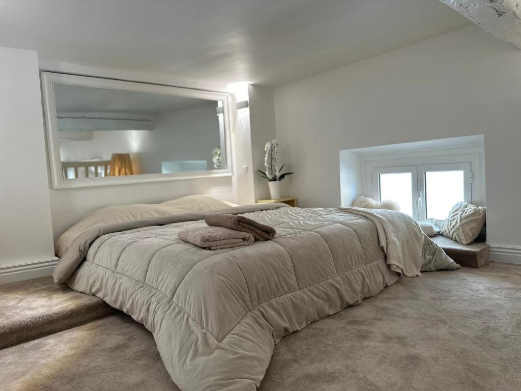 une chambre avec un grand lit avec un grand miroir dans l'établissement Gaya, à Nice