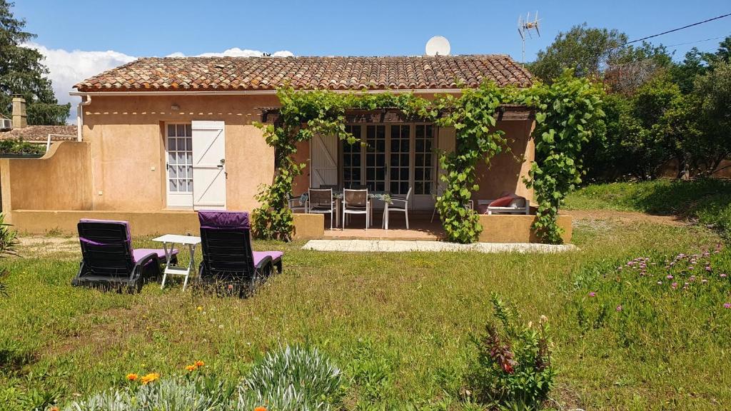 une maison avec deux chaises et une table dans une cour dans l'établissement Villa les Arbousiers, à Saint-Tropez