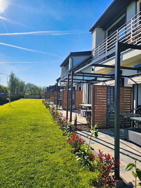 a building with a grass yard next to a building at Baltic Harmony Villas - Grzybowo in Grzybowo