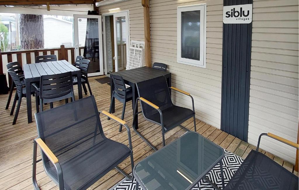 patio z krzesłami i stołami oraz znak na budynku w obiekcie Mobile Home Ac Proche Plages w mieście Saint-Julien-en-Born