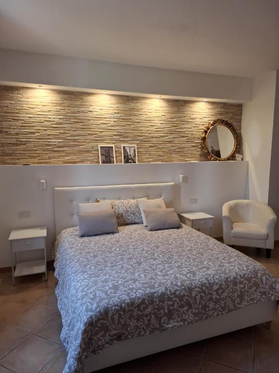 a bedroom with a large bed and a mirror at Centro mare residence affitta alloggi in Porto Torres