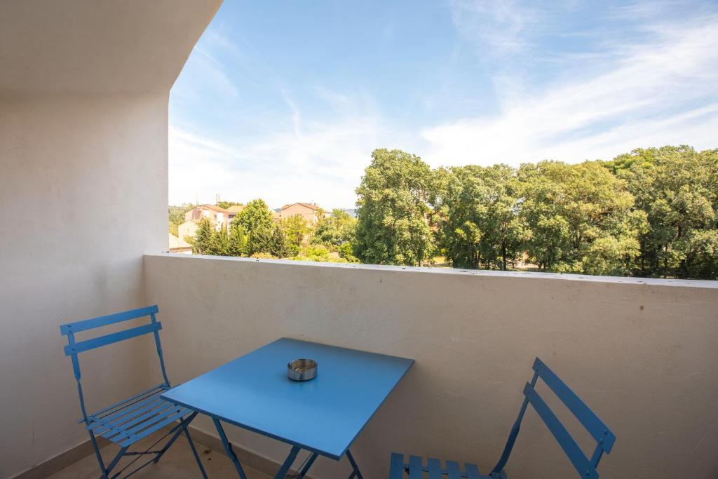 une table bleue et deux chaises sur un balcon dans l'établissement Appartement 113, à Cogolin