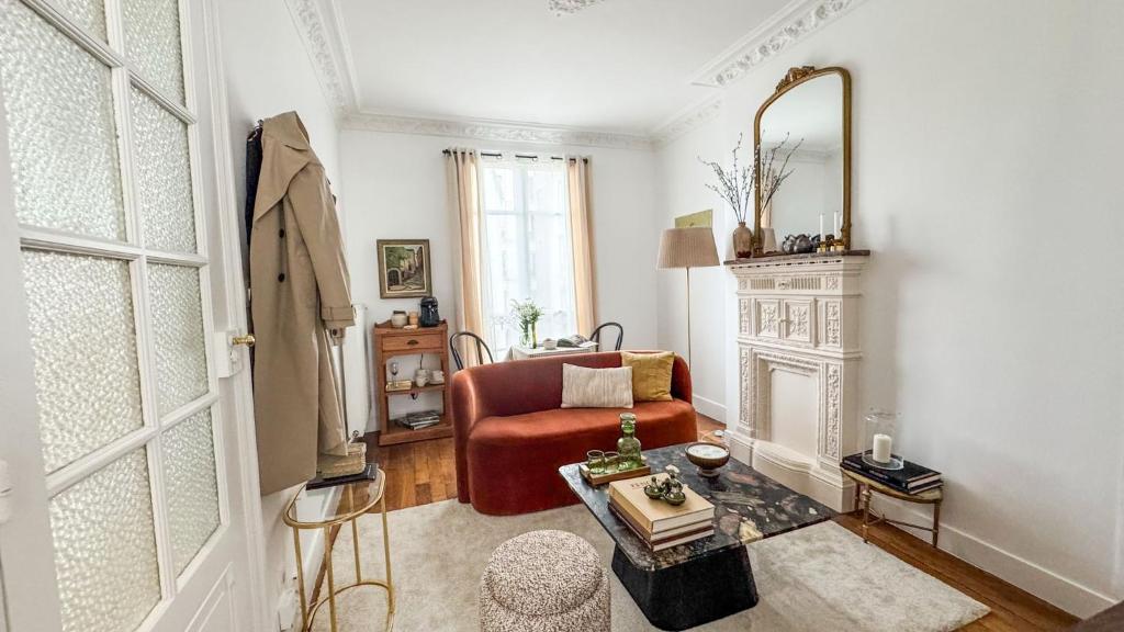 - un salon avec une chaise rouge et un miroir dans l'établissement Le Repaire Tranquille, à Paris