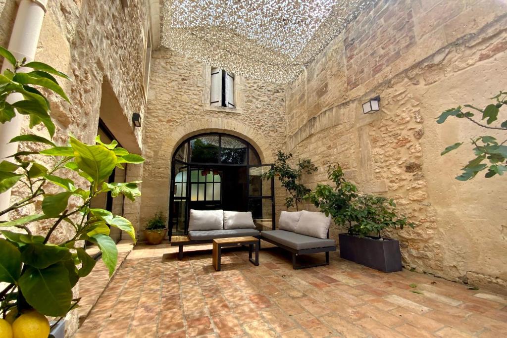 a patio with two chairs and a table in a building at La Maison de la Place - Charming house with swimming pool & exposed stone in Mudaison
