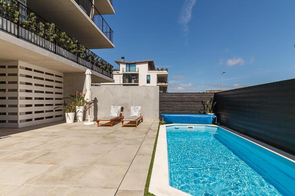 a swimming pool in the backyard of a house at Lina Beach Villa by Home Sweet Home Aveiro in Praia da Barra
