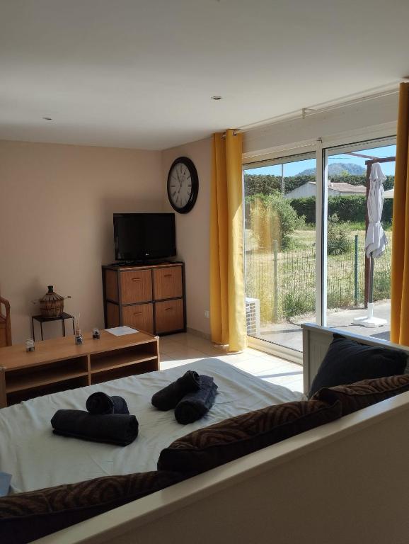 - une chambre avec un grand lit et une horloge murale dans l'établissement Studio La Gière, à Beaumes-de-Venise