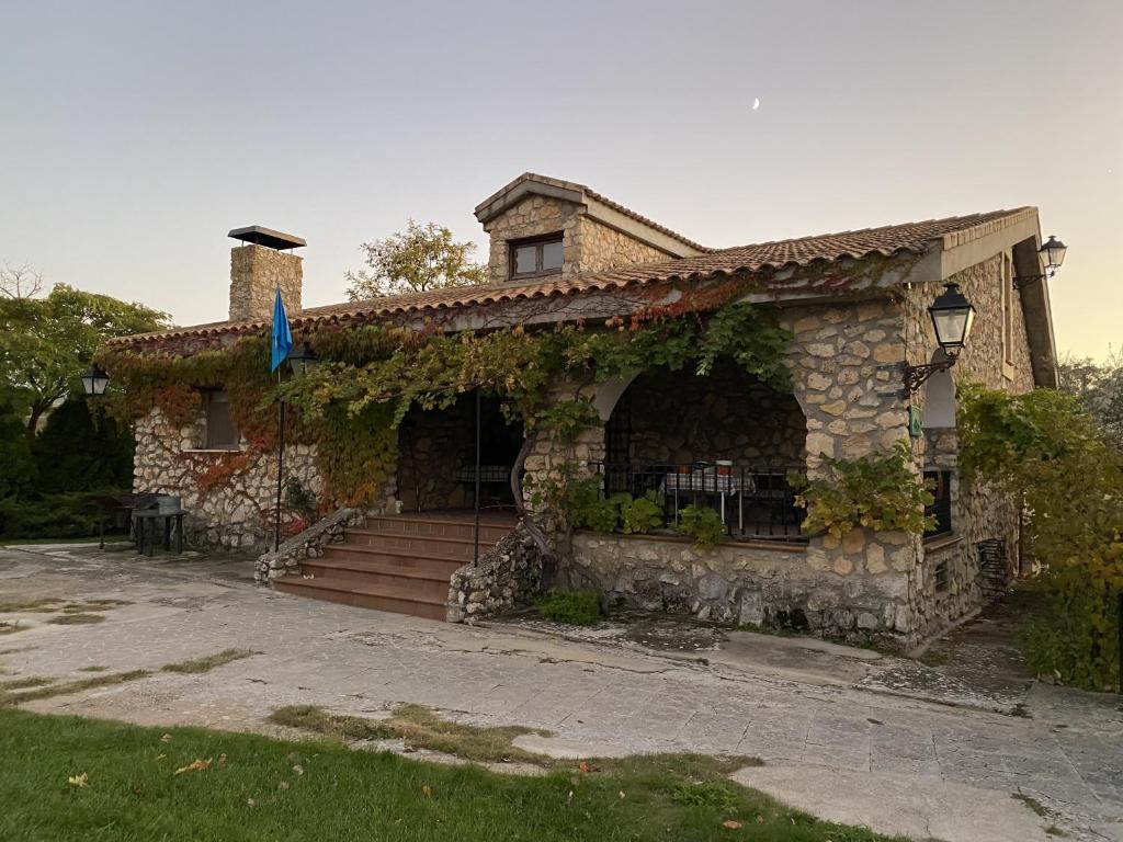 a stone house with a staircase in front of it at Casa Rural con chimenea, piscina y vistas al río in Zorita de los Canes