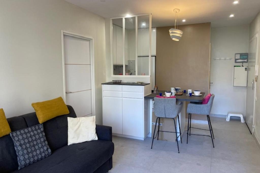 un salon et une cuisine avec un canapé et une table dans l'établissement Apartment for 2 with balcony - near beach, à Cannes