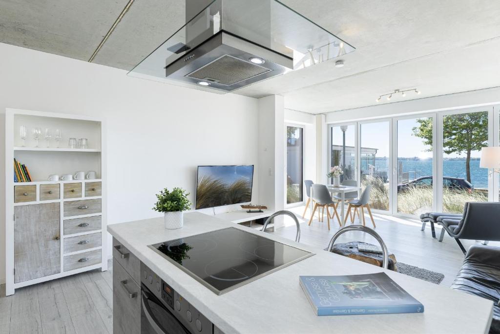 a kitchen and living room with a view of the ocean at Strandweg 6-7 Dünengras in Möltenort