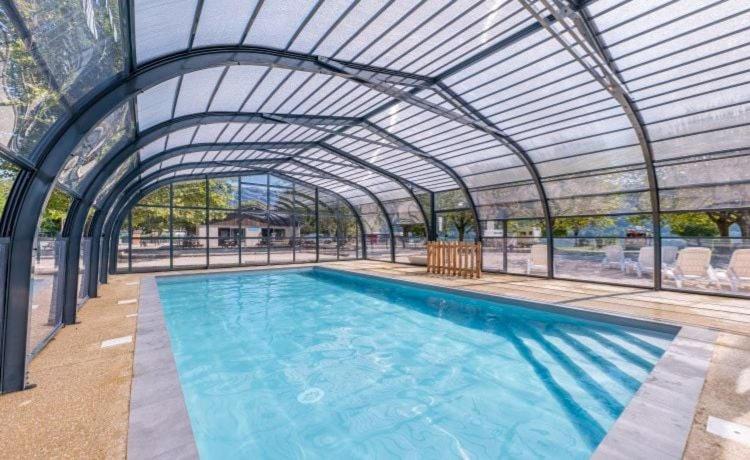 a large swimming pool with a glass roof at mobil home 4 personne 2 chambre vu lac a condes in Condes