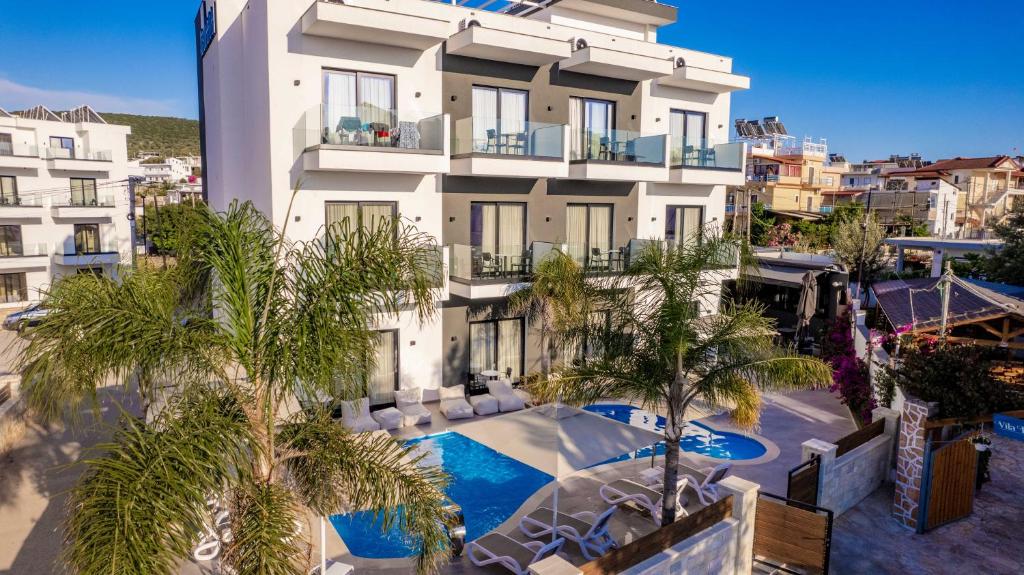 um edifício de apartamentos com piscina e palmeiras em Absolute Hotel Ksamil em Ksamil