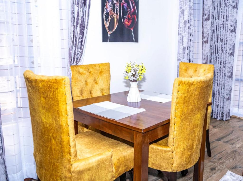 ディアニ・ビーチにあるTropical 2BR Haven in Dianiの木製のテーブルと黄色の椅子のあるダイニングルーム