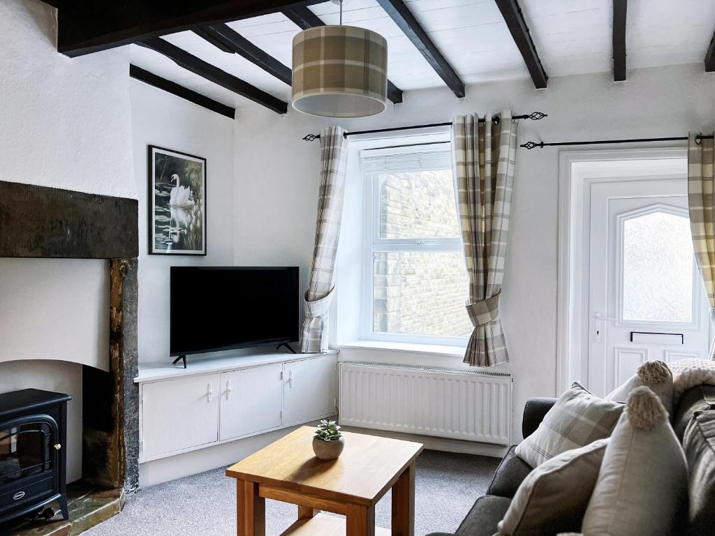 a living room with a couch and a tv at The Willow Nook in Pateley Bridge