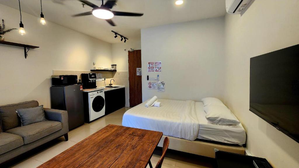 a bedroom with a bed and a couch and a table at THE SHORE KK CITY VIEW S15 By BC 亚比城市景观 in Kota Kinabalu