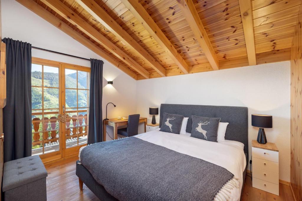 RiddesChalet Belle Vue – Alpine Charm with a View to Remember的一间卧室设有一张大床和木制天花板