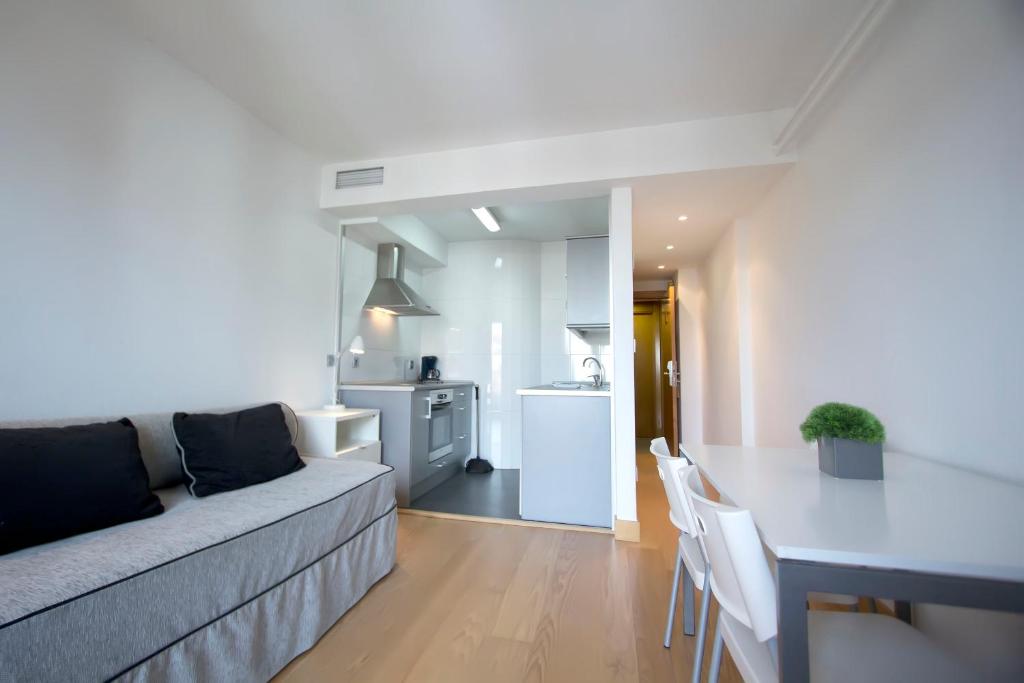 ein Wohnzimmer mit einem Sofa und einem Tisch in der Unterkunft Apartamentos Jauregui in Hondarribia