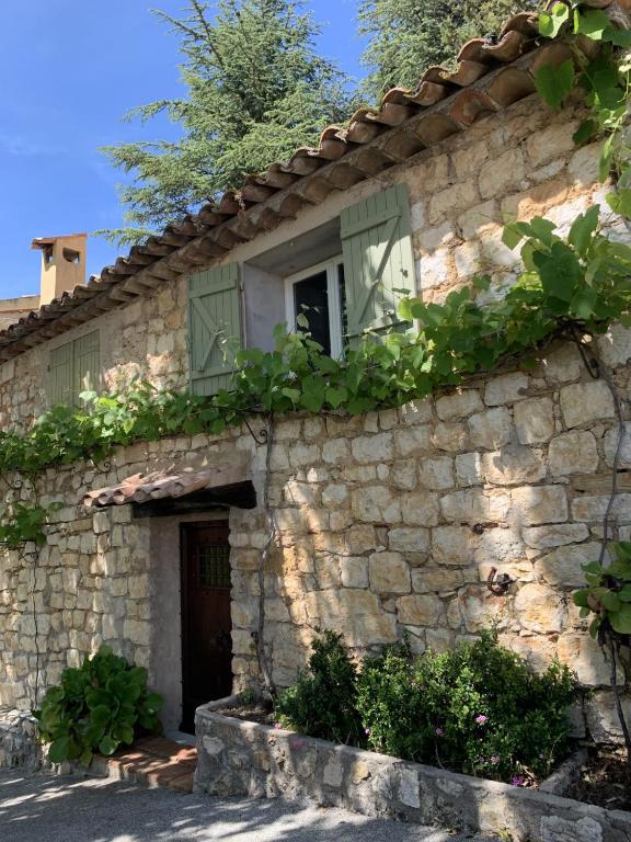 - un bâtiment en pierre avec une porte et une fenêtre dans l'établissement La Sanglière, à Ampus