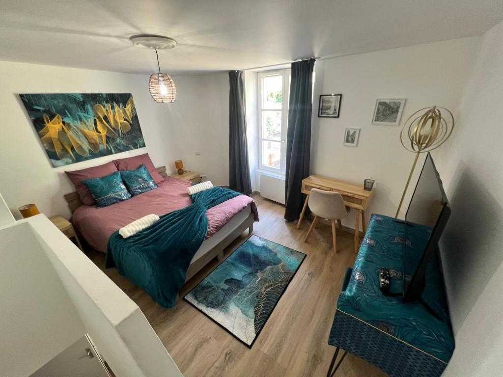 a small bedroom with a bed and a desk at Montbel'appart-Le duplex jardin terrasse in Montbéliard