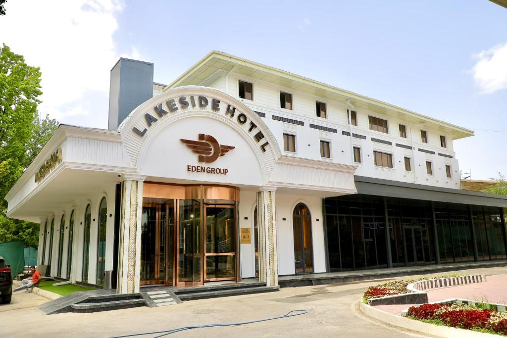 a large white building with a sign on it at LakeSide Hotel by EDEN Group in Tashkent