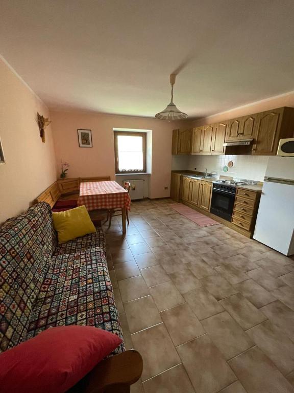 a living room with a table and a kitchen at Appartamento Bonomelli in Enguiso