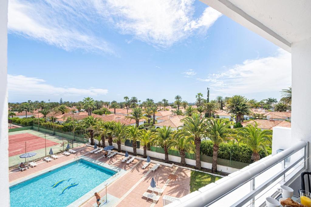 a balcony with a swimming pool and palm trees at Holiday Dream Maspalomas in Maspalomas