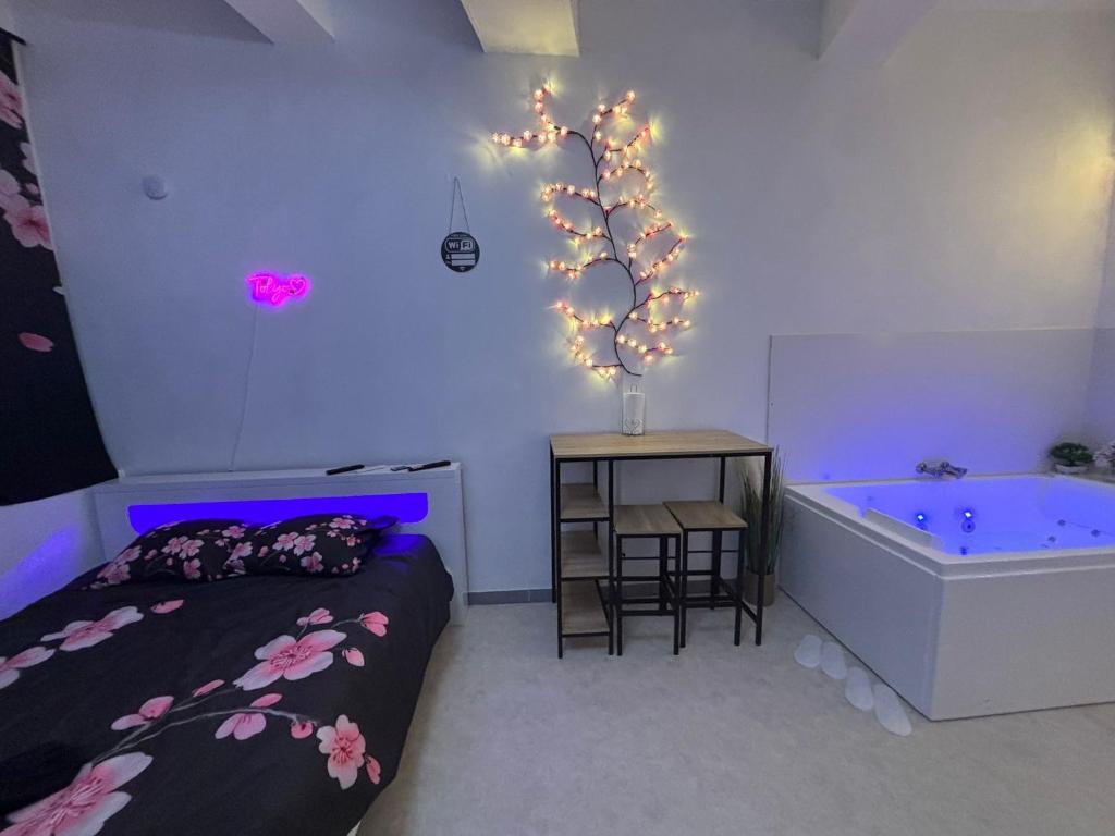 - une chambre avec un lit et une baignoire éclairée dans l'établissement Tokyo love, à Montpellier