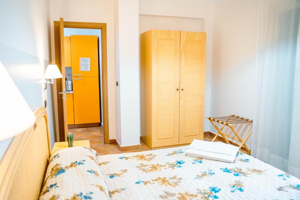 a bedroom with a bed and a yellow door at Le Tartarughe Aparthotel in Letojanni