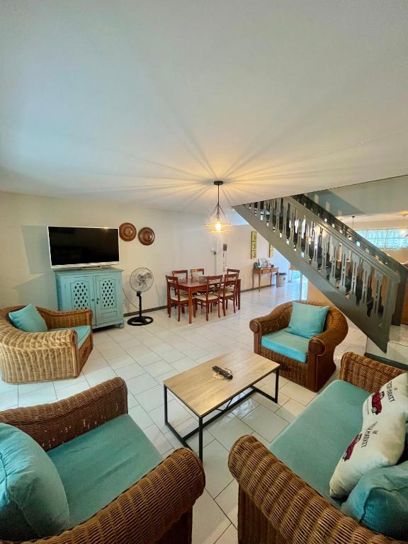 a living room with couches and a table and a staircase at Nenuphar 3 Bedroom-Apartment in Flic-en-Flac