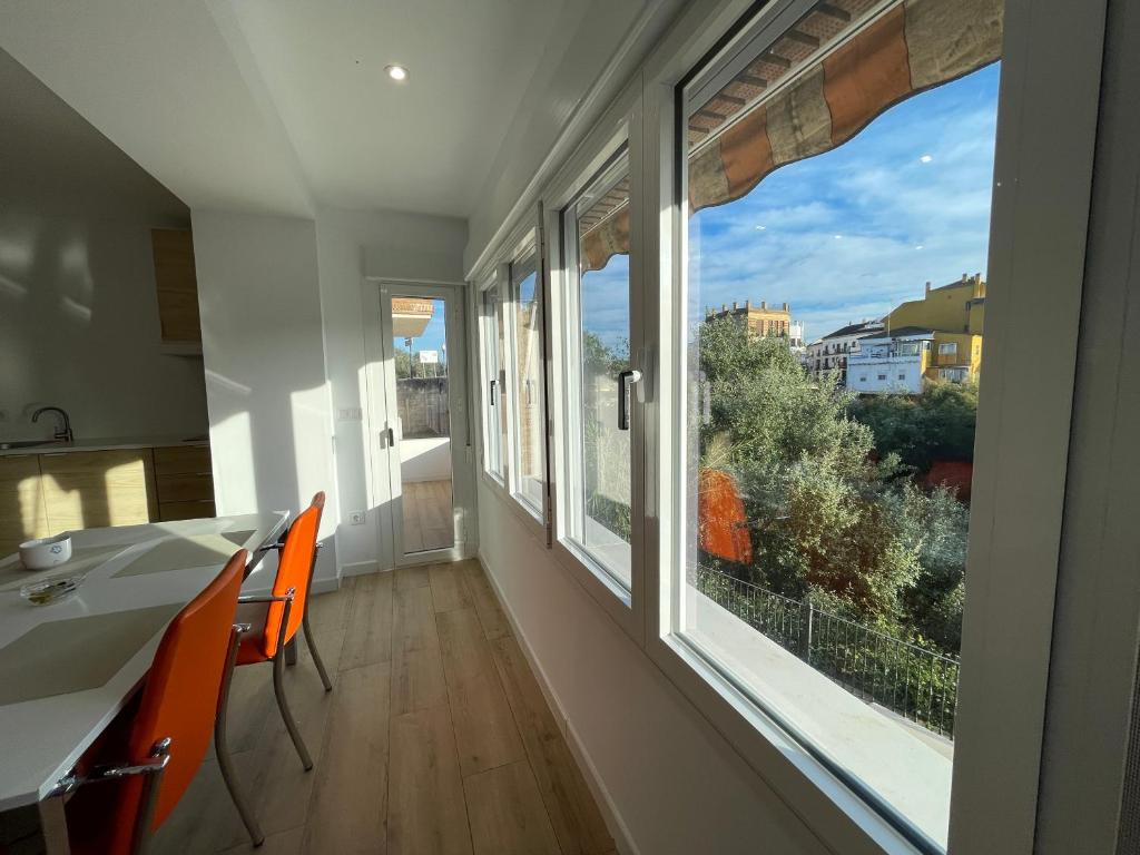 a room with two windows and a table and chairs at Mirador al puente del río Genil in Puente-Genil