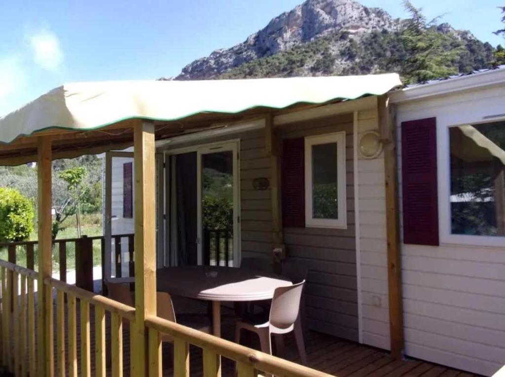 - une terrasse couverte avec une table et des chaises dans l'établissement Camping 3 étoiles - Piscine - cbgcaia, à Buis-les-Baronnies