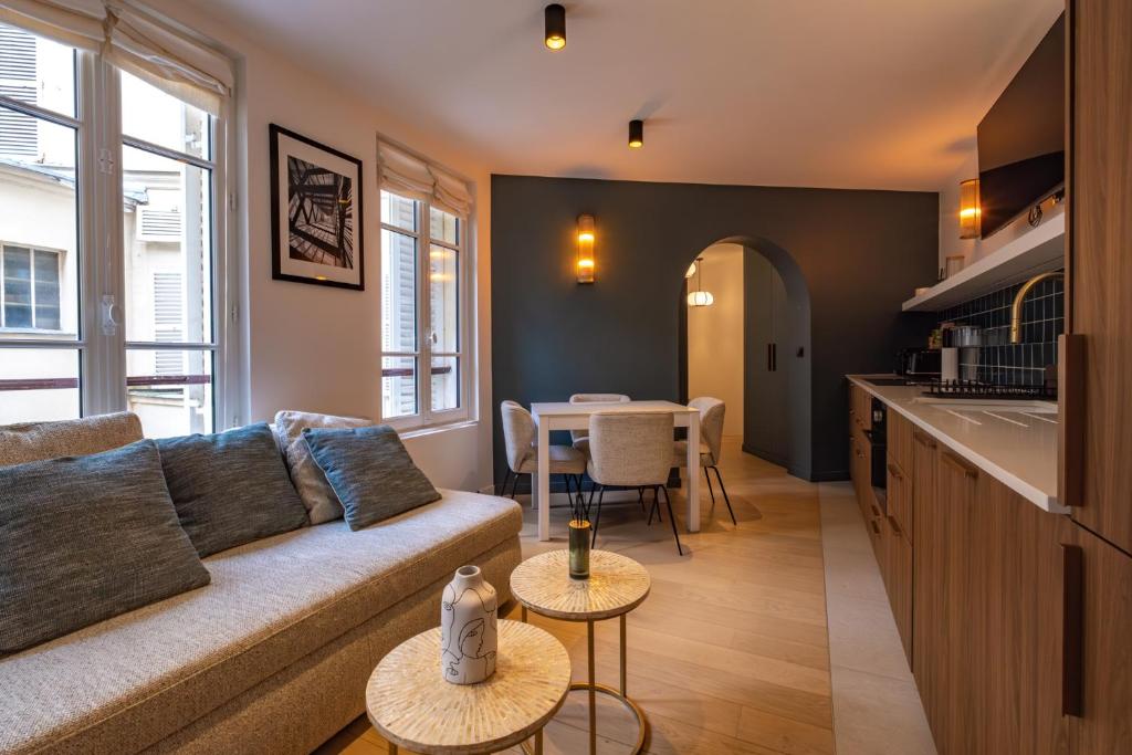 una sala de estar con un sofá y una mesa en 4 Guest - Hausmanian Flat Arc de Triomph, en París
