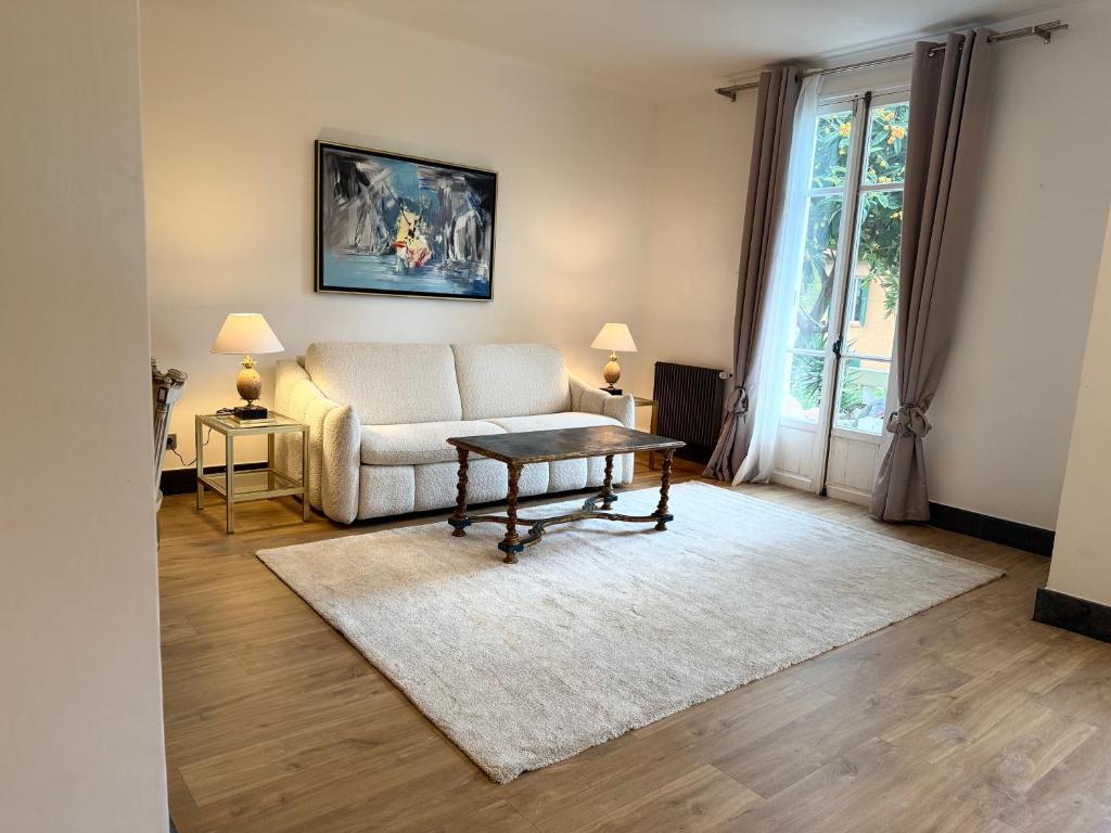 una sala de estar con un sofá y una mesa en Magnifique studio entier avec terrasse Saint Jean Cap Ferrat, en Saint-Jean-Cap-Ferrat
