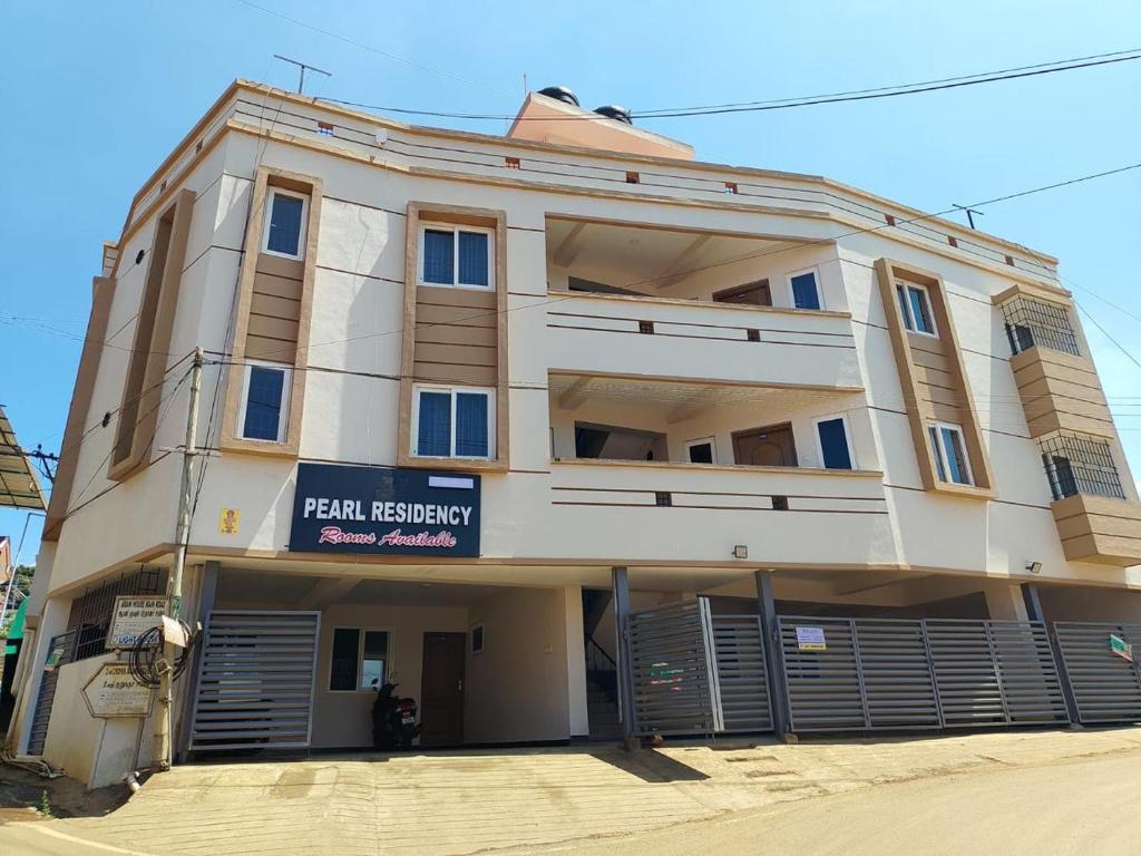 a large white building with a sign on it at The Pearl Residency 2BHK 3BHK Apartments in Ooty