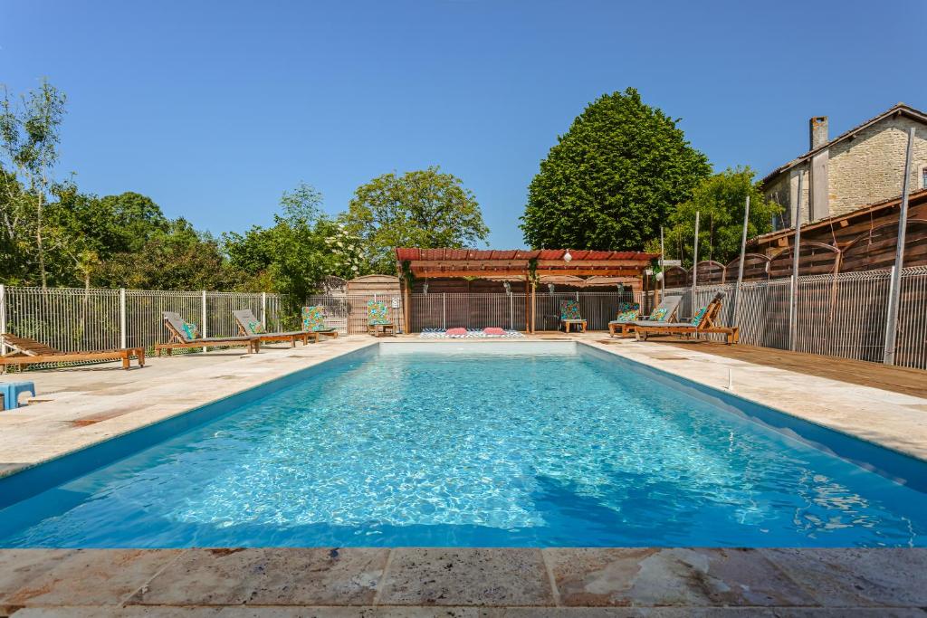 une grande piscine avec de l'eau bleue dans l'établissement Chambre d'hote Emeraude, à Genouillé
