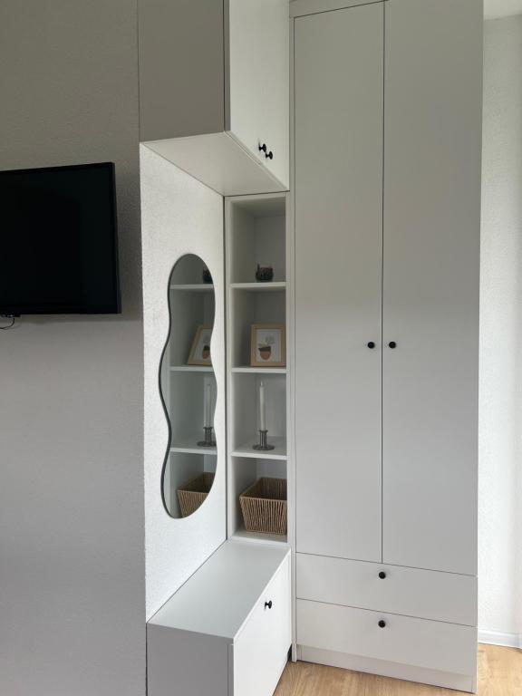 a white wardrobe with a mirror and a tv at Home Away From Home in Jajce