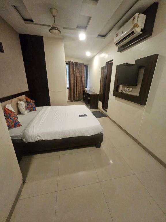 a bedroom with a bed and a flat screen tv at Prime Hotel Addore Palácée - Near Mumbai Airport , Visa Consultant , Jio World Convention Centre BKC in Mumbai