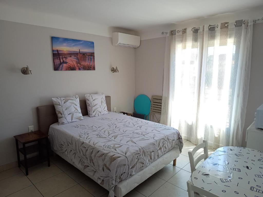 une chambre blanche avec un lit et une fenêtre dans l'établissement Chambre privée climatisée chez particulier, WIFI, à Perpignan