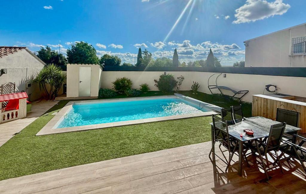 a swimming pool in a yard with a table and chairs at 4 Bedroom Beautiful Home In Rognac in Rognac
