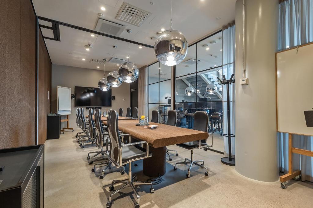 赫尔辛基Unity Helsinki - A Studio Hotel的一间会议室,配有长桌子和椅子